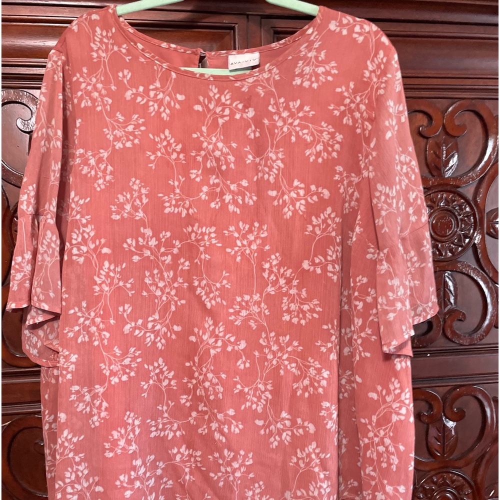 Layered top with a peach color and decorative design. Lightweight, love this!